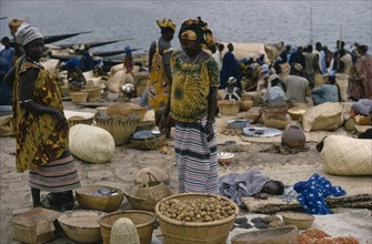 MALI, Mopti, Women traders with baskets of goods and sleeping child at market.