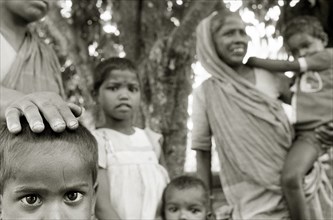 INDIA, West Bengal, Extended family wait for social security benefits in a West Bengali village.