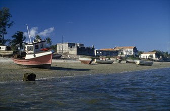 MOZAMBIQUE, Ile de Ibo, "Fishing boats pulled up on shore with crenellated walls of fort behind,"