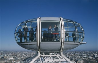 ENGLAND, London, British Airways London Eye capsule and the London skyline with tourist waving to