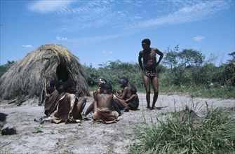 NAMIBIA, Great Namaqualand, Kalahari Desert, Bushmen tribespeople outside thatched domed hut.