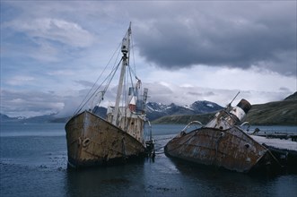 ANTARCTICA, South Georgia, Grytviken, Abandoned whale catchers semi capsized in the water.