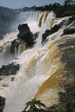 ARGENTINA, Iguazu Falls, "Water pouring over the edge, past large rocks."