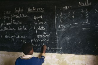 LESOTHO, Education, School, Boy in classroom writing in English on chalk board