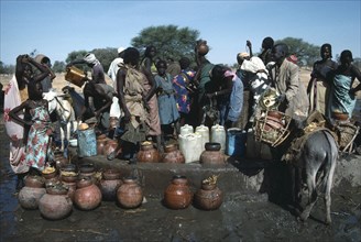 SUDAN, Habila Settlement, Chadian refugees gathered at well in settlement near El Geneina.