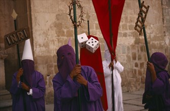 MEXICO, Oaxaca, Penitents holding staffs displaying different symbols during Holy Week.