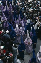 ECUADOR, Quito, Good Friday procession in Plaza San Francisco.  Penitents wearing purple robes and