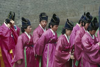 SOUTH KOREA, Seoul, Court musician and dancers in line entering memorial site containing spirit