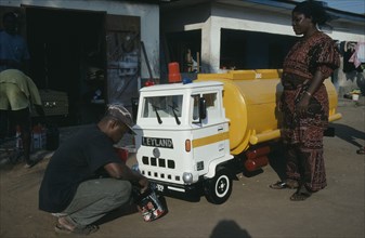 GHANA, South, Nungua, Craftsman painting oil tanker shaped coffin for driver Peter Borkety Kuwono