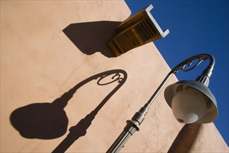 USA, New Mexico, Santa Fe, Street lamp and gutter detail with shadows on adobe style building