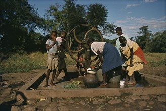 ZAMBIA, Water, Women and children at well.
