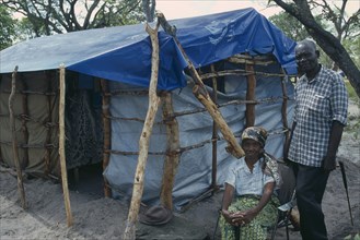 ZAMBIA, Mayukwayukwa Camp, Elderly couple beside shelter in camp for Angolan refugees.