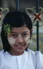 MYANMAR, Yangon, Portrait of young girl with sandlewood paste on her cheeks and nose used as a