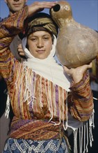 TURKEY, East, Young woman carrying calabash gourd for water.