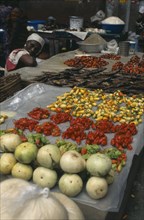 IVORY COAST, Abidjan, Display of vegetables and fish for sale in the covered market with female