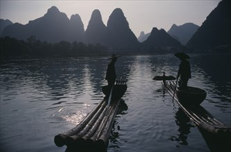 CHINA, Guangxi Province, River Li, Cormorant fishermen silhouetted on stretch of river in the