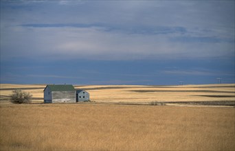 USA, North Dakota, Vast expanse of prairie and distant farm building