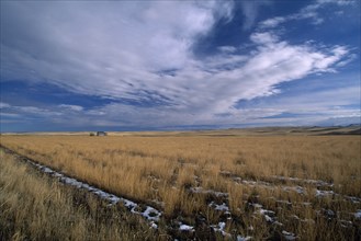 USA, North Dakota, Vast expanse of prairie and distant farm building