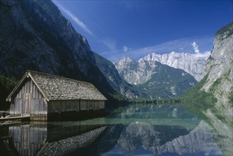 GERMANY, Berchtesgaden, Konigssee, A boathouse amidst tranquil water on the far side of the Obersee