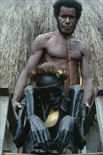 INDONESIA, Irian Jaya, Baliem Valley, "Jiwika Village. Dani Warrior man holding smoked ancestral