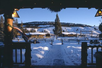 USA, Wyoming, Dubois, View of Guest cabins at the Triangle C Dude Ranch in the snow from building