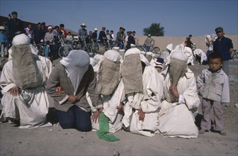 CHINA, Gansu Province, Taoist funeral with close relatives wearing white shrouds for mourning.