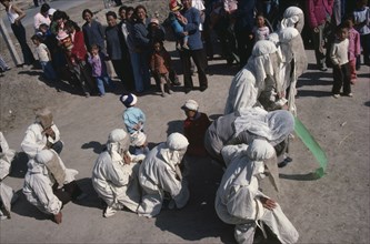 CHINA, Gansu Province, Taoist funeral with close relatives wearing white shrouds for mourning.