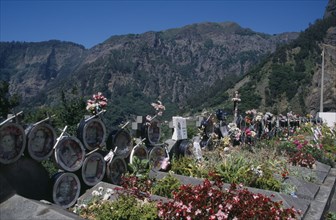 PORTUGAL, Madeira, Camara de Lobos, Curral das Freiras. Photographs of the dead with flowers