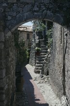 FRANCE, Provence Cote D Azur, Alpes Maritime, Eze. Walled alley way with stone steps leading up to