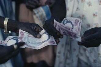 NIGERIA, Money, Cropped shot of money changing hands.