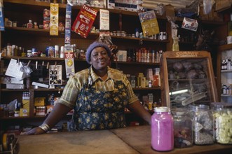 SOUTH AFRICA, Gauteng, Soweto, Portrait of shopkeeper behind counter with goods arranged on shelves