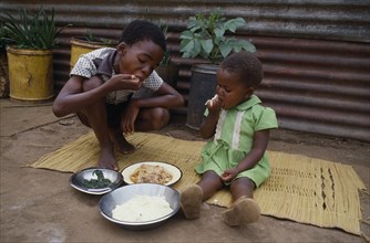 SOUTH AFRICA, Transvaal, Children eating meal using right hands.
