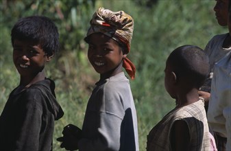 MADAGASCAR, People, Children , Portrait of a girl wearing a headscarf standing amongst two other