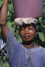 MADAGASCAR, People, Women, Portrait of a woman carrying a water bucket on her head