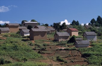 MADAGASCAR, Architecture, Road to Ambalavao. Thatched huts set into hillside
