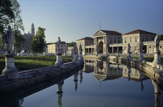 ITALY, Veneto, Padua, Prato della Valle.  Canal surrounding oval green island along which stand