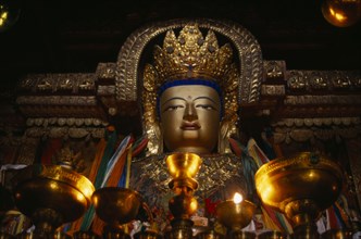 CHINA, Tibet, Gyantse, "Butter lamps and a statue of Sakyamuni, the present Buddha, in Pelkor Chode
