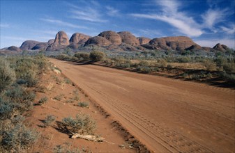 AUSTRALIA, Northern Territory, Uluru National Park, "A dirt road through the park, with Katatjuta,