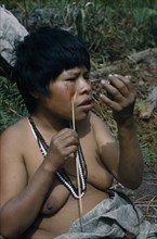 COLOMBIA, Sierra de Perija, Yuko - Motilon ., "Woman applying red “Achiote” facial paint extracted