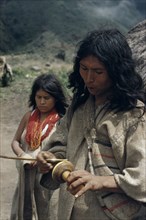 COLOMBIA, Sierra Nevada de Santa Marta, Kogi Tribe, "Man rubs lime encrusted gourd with ritual