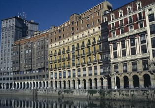 SPAIN, Basque Country, Bilbao, Riverside arcade with flats and offices.