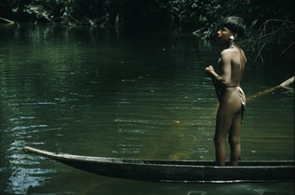 COLOMBIA, Choco Region, Noanama Tribe, "Ricardino, a young boy with a silver ear plug paddles his
