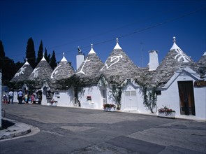 ITALY, Puglia, Bari Provence, "White Trulli buildings with runic symbols painted on the grey stone