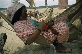 COLOMBIA, Guajira Peninsula, Guajiro / Wayuu Tribe, Wayuu woman sews a coloured “faja” / woven