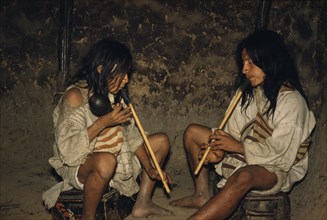 COLOMBIA, Sierra Nevada de Santa Marta, Kogi Tribe, Men playing “kuisi” flutes in San Miguel