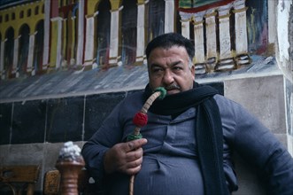 SYRIA, Damascus, Man smoking traditional water pipe or hookah.