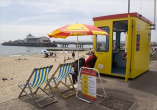 ENGLAND, Dorset, Bournemouth, Lifegaurd station on The East Beach with Bournemouth Pier beyond