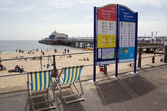 ENGLAND, Dorset, Bournemouth, Deckchairs beside an information sign on The East Beach promenade