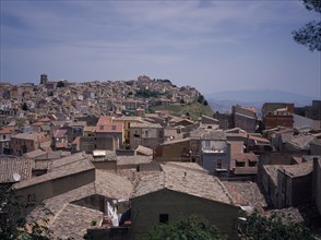 ITALY, Sicily, Enna Province, View East over the rooftops of the hilltop city towards Mount Etna