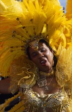 ENGLAND, London, Notting Hill carnival woman in bright yellow costume.